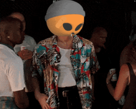 a man with an alien mask on his head in a crowd