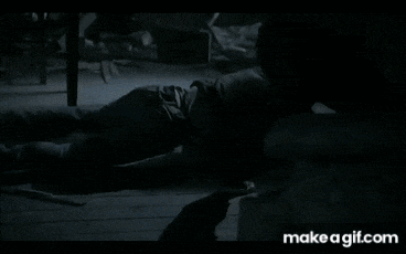 a person is laying on a bed in a dark room with a make a gif.com website in the corner .