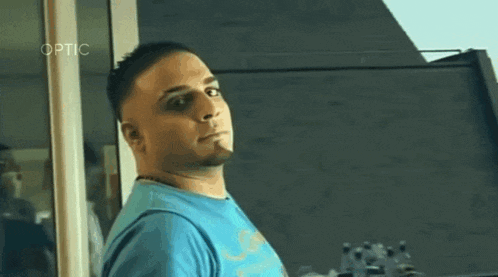 a man in a blue shirt is looking out of a window .