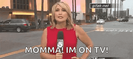 a woman in a red dress is holding a microphone and says momma ! im on tv !