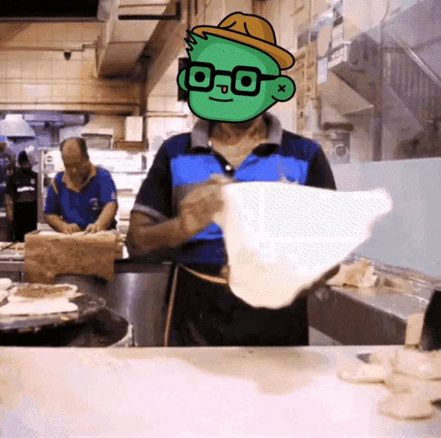 a man wearing glasses and a hat is holding a piece of dough in front of his face