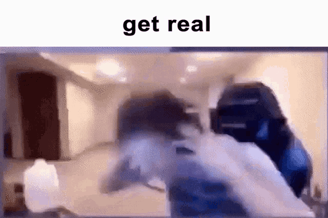 a blurry picture of a person sitting in front of a computer screen with the words `` get real '' .