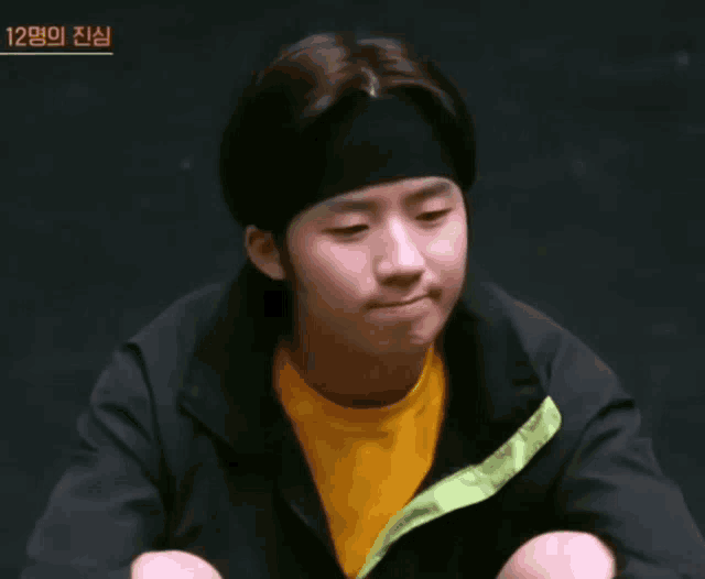 a young man wearing a headband and a yellow t-shirt