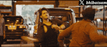 two men are fighting in front of a sign that says ' bharatsam ' on it