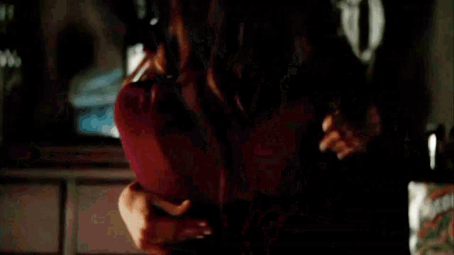 a woman is hugging another woman in a dark room in a car .