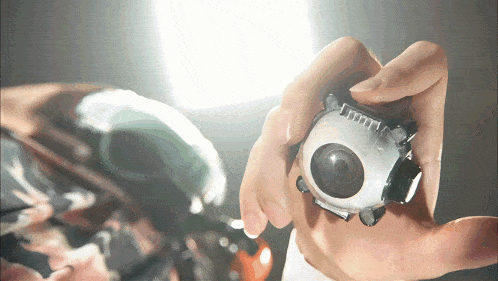 a person is holding a small object in their hand that looks like a camera