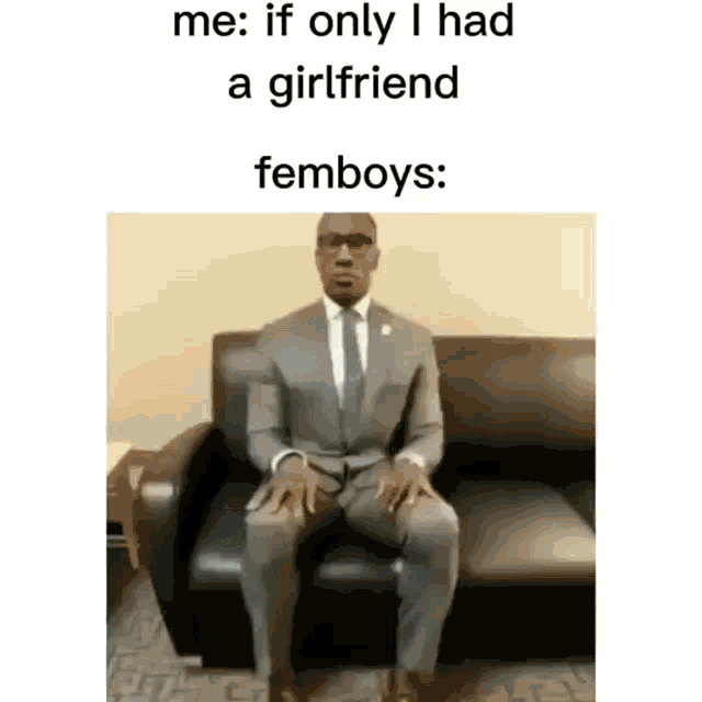 a man in a suit and tie is sitting on a black couch .