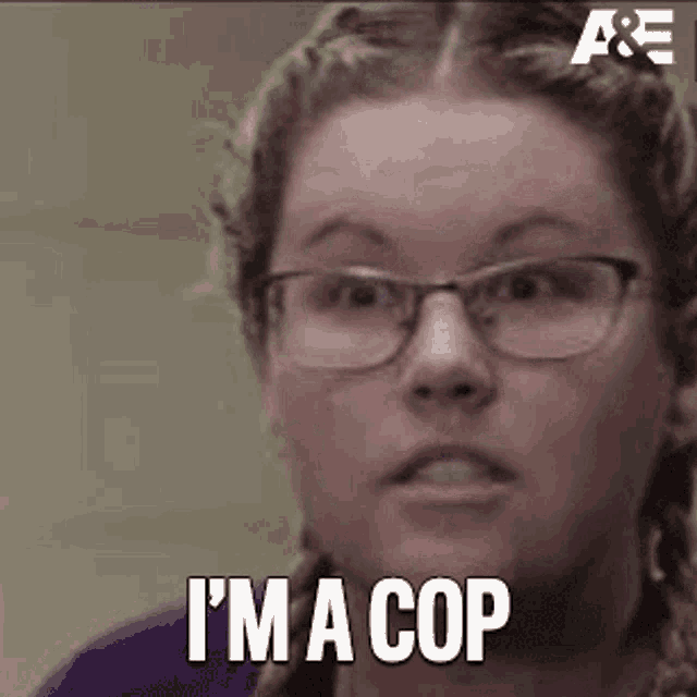 a close up of a woman wearing glasses and saying `` i 'm a cop '' .