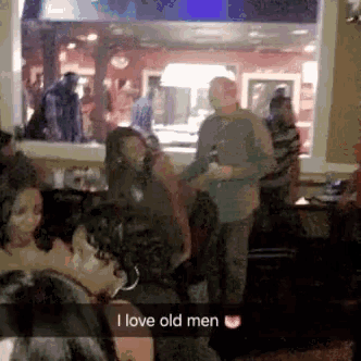 a group of people are gathered in a room with the words i love old men
