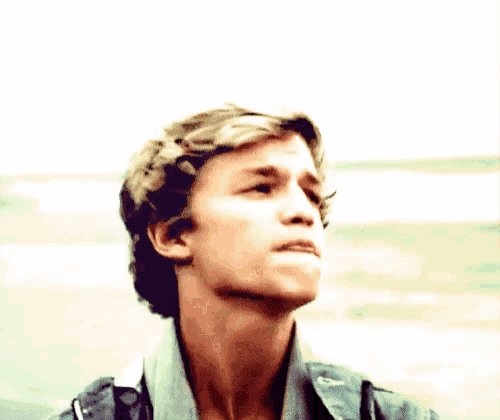 a close up of a young man 's face with his mouth open .