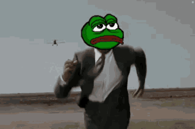 a man in a suit and tie with a green frog on his head is running in a desert .