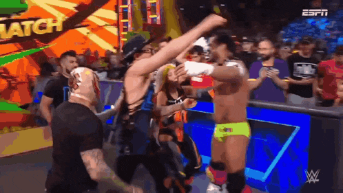 a group of wrestlers are standing in a ring with the word match on the screen