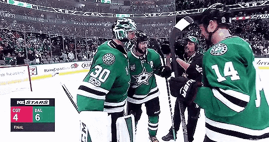 a group of hockey players are standing on the ice in a stadium .