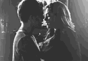 a man and a woman kissing in a black and white photo