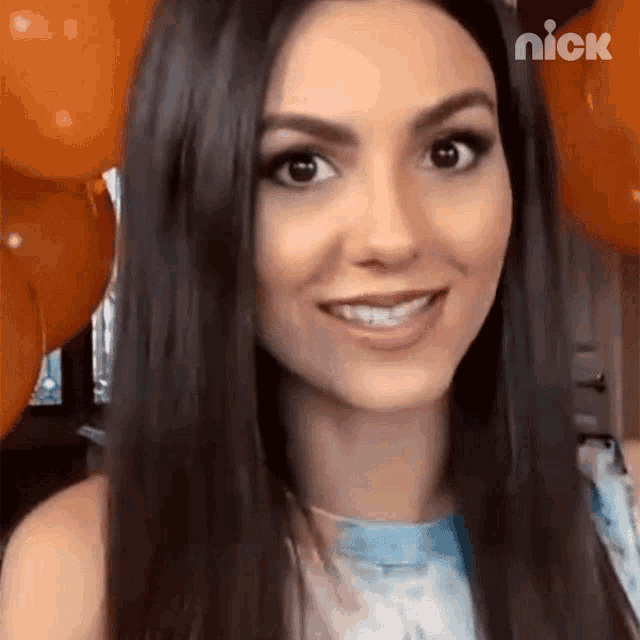 a close up of a woman 's face with balloons in the background and the word nick on the bottom