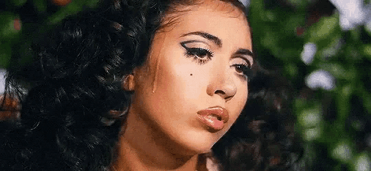 a close up of a woman 's face with a tear coming out of her eyes .