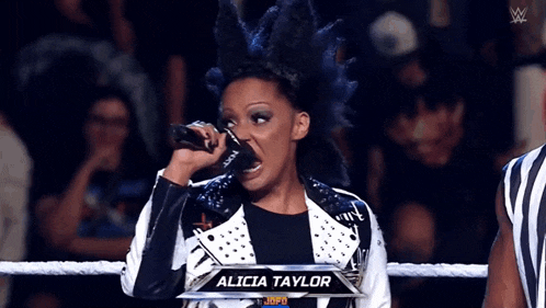 a woman with a mohawk is singing into a microphone with the name alicia taylor above her
