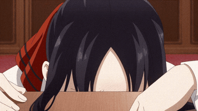 a girl with long black hair is covering her face with her hand