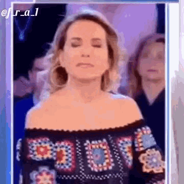 a woman with her eyes closed is standing in front of a crowd .