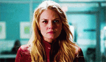 a woman with blonde hair and a red jacket is looking at the camera with a sad look on her face .
