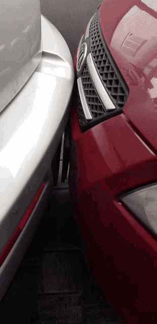 a red car is parked next to a silver car