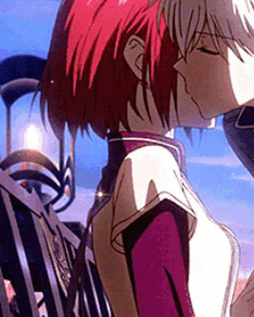 a man and a woman are kissing in front of a fence . the woman has red hair and the man has white hair .