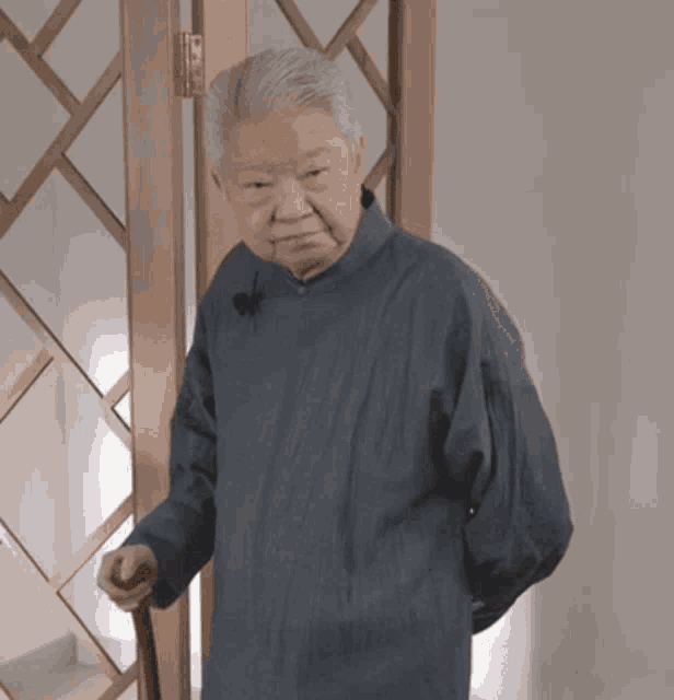 a man in a blue coat holds a cane