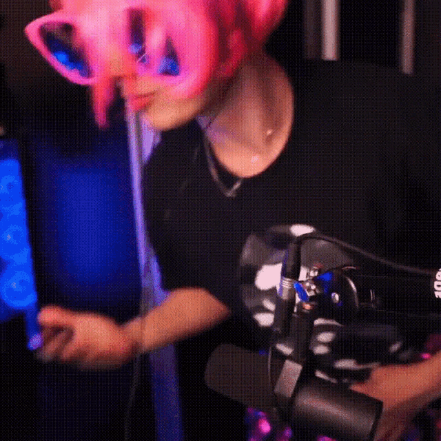 a woman wearing a pink wig and sunglasses is holding a microphone