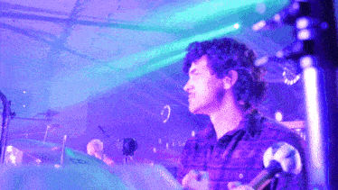 a man singing into a microphone in front of a drum set that says ' sd ' on it