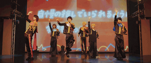 a group of people are dancing in front of a screen that says ' a ' on it