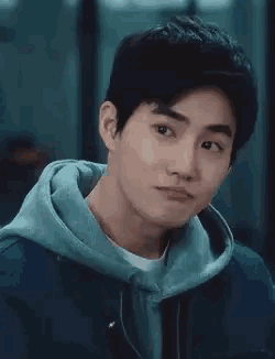 a close up of a man wearing a hoodie and a jacket .