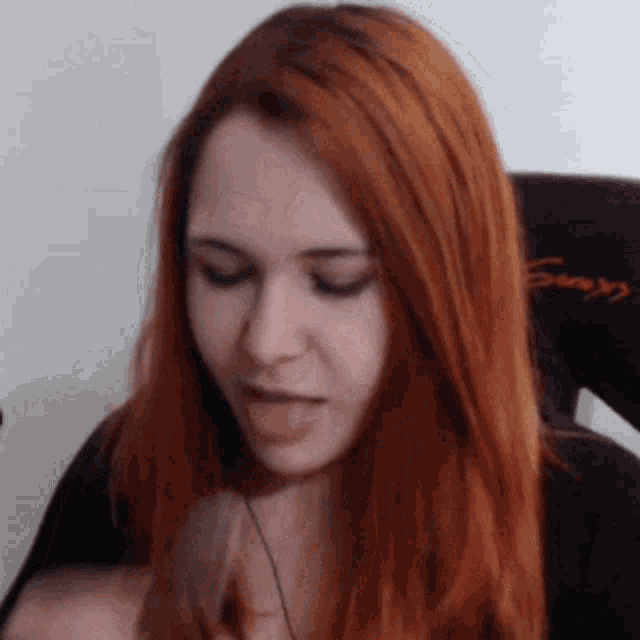 a woman with red hair is sitting in a chair with the word sony on it .