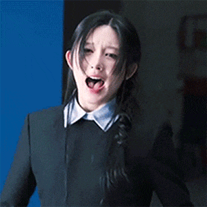 a woman in a suit and tie is making a funny face