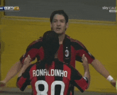 a group of soccer players are hugging each other and one of them has the number 21 on his back
