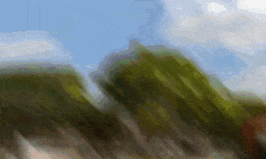 a blurry picture of a mountain range with trees in the foreground