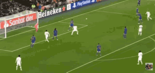 a soccer game is being played in front of a banner that says santai der heineken