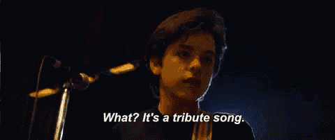 a young boy singing into a microphone with the words what ? it 's a tribute song ..
