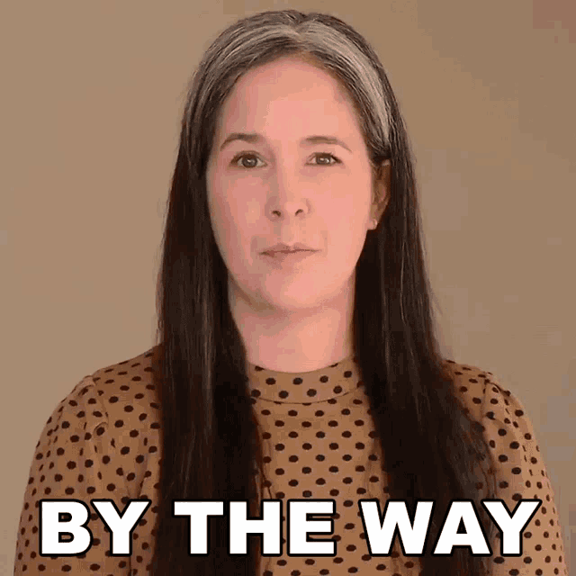 a woman wearing a polka dot top says by the way