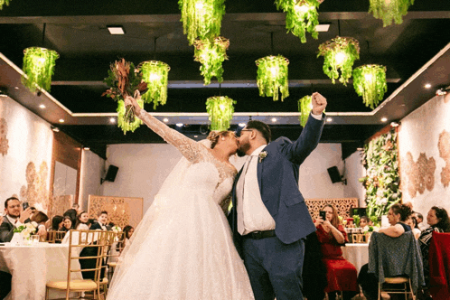 a bride and groom kissing in front of a crowd of people