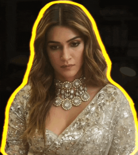 a woman wearing a necklace and a sequined top