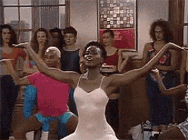 a ballerina is dancing in front of a group of people .