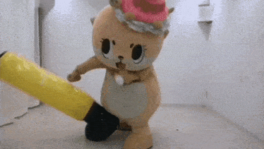 a mascot is holding a yellow balloon in his hand .