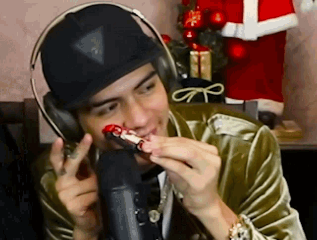 a man wearing headphones and a hat is holding a toy in his hand
