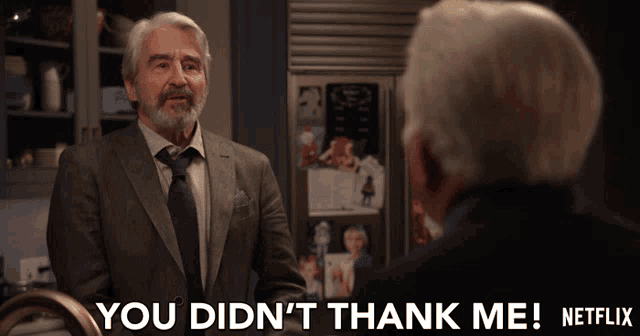 a man in a suit and tie says " you didn 't thank me " to another man