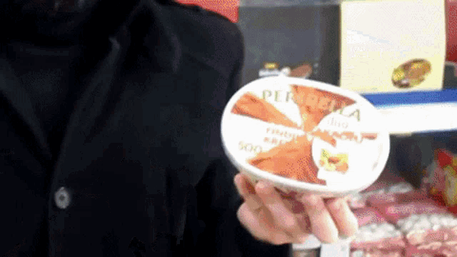 a person is holding a container of perretta ice cream