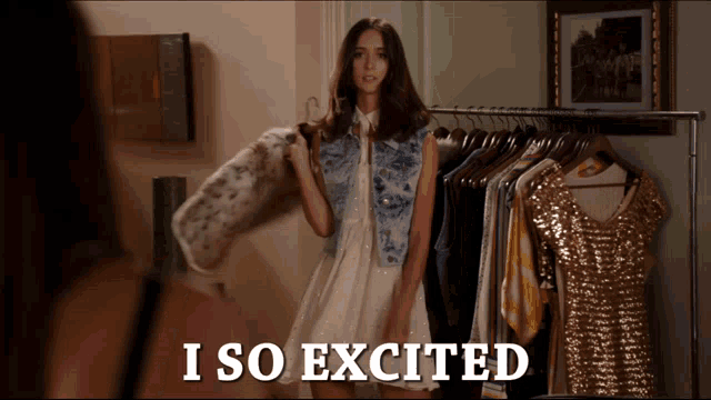 a woman in a white dress is standing in front of a rack of clothes and the words i so excited are above her