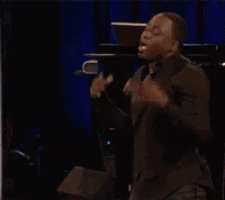 a man is walking on a stage in front of a crowd of people