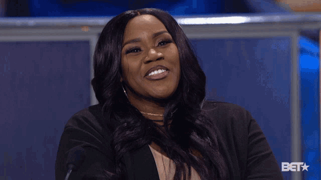 a woman is laughing in front of a bet star