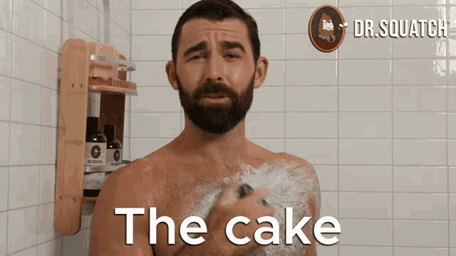 a man taking a shower with the words " the cake " written on his chest