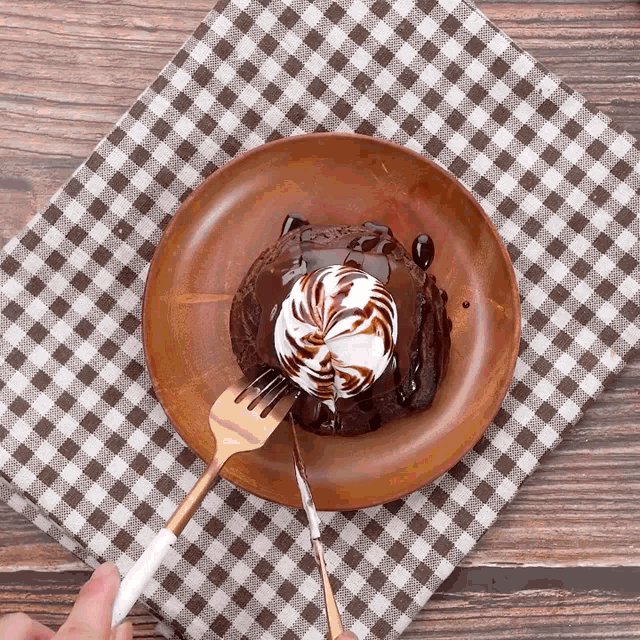 a chocolate cake with whipped cream on top is on a plate with a fork and knife